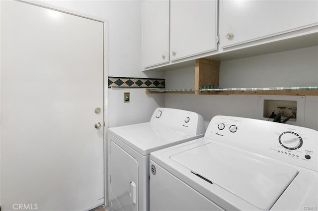 clothes washing area featuring cabinets and washer and dryer