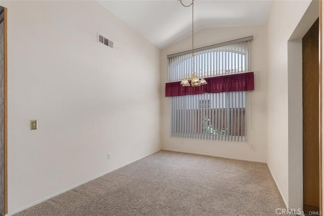 carpeted spare room featuring vaulted ceiling