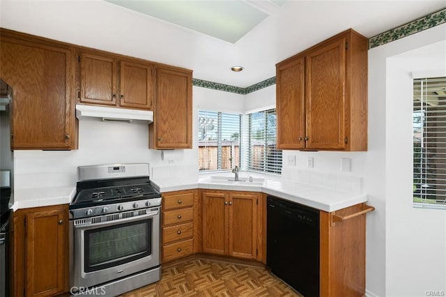 kitchen with sink, stainless steel gas range oven, dishwasher, and light parquet flooring