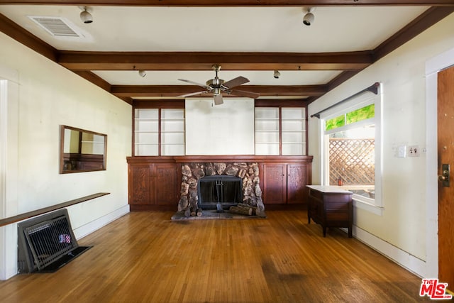 unfurnished living room with hardwood / wood-style flooring, beam ceiling, ceiling fan, and a fireplace