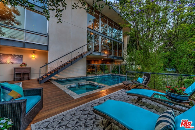 view of swimming pool with an in ground hot tub and a wooden deck