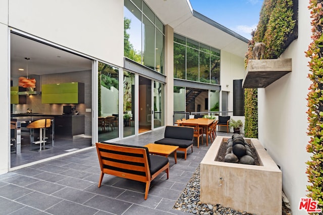 view of patio featuring an outdoor living space with a fire pit