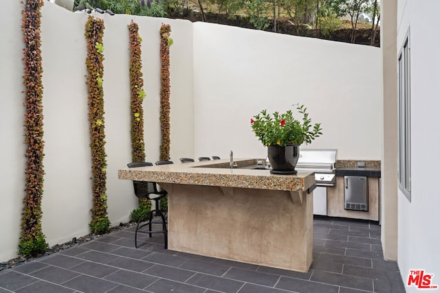 view of patio featuring a bar and exterior kitchen