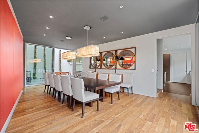 dining area featuring a wall of windows and light wood-type flooring