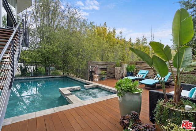 view of swimming pool with a wooden deck and an in ground hot tub