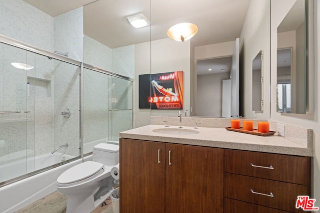 full bathroom with toilet, vanity, and shower / bath combination with glass door