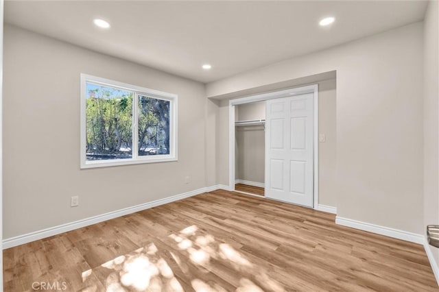 unfurnished bedroom featuring a closet and light wood-type flooring