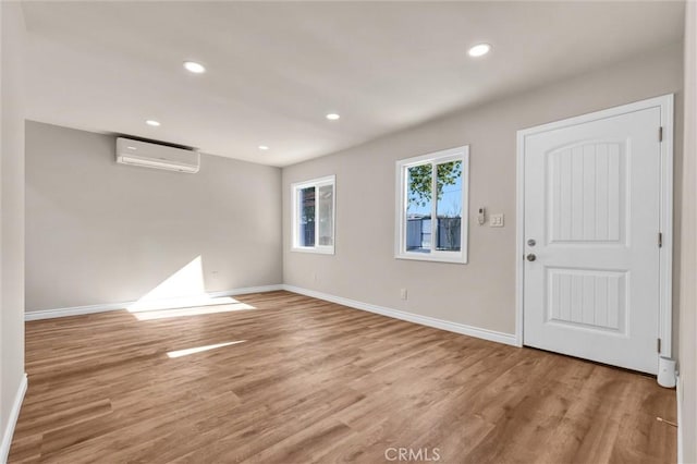 entrance foyer featuring light hardwood / wood-style floors and a wall unit AC