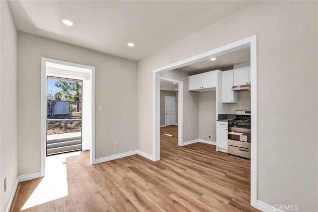 kitchen featuring light wood-type flooring, white cabinetry, and stainless steel range with gas stovetop