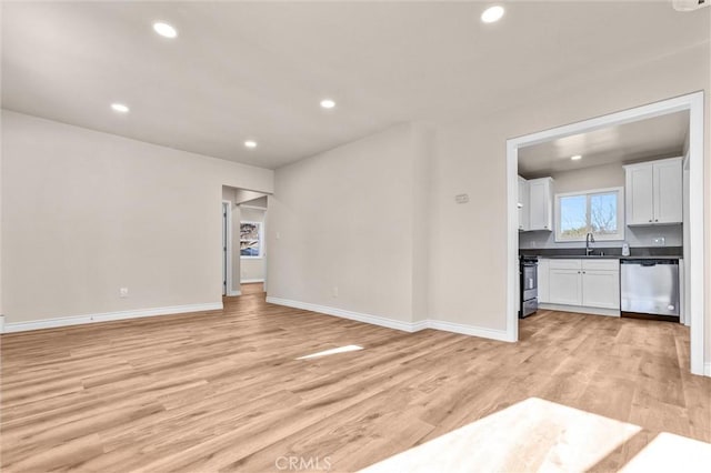 unfurnished living room featuring light hardwood / wood-style floors and sink