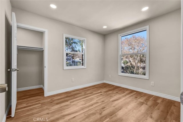 unfurnished bedroom with light hardwood / wood-style floors and a closet