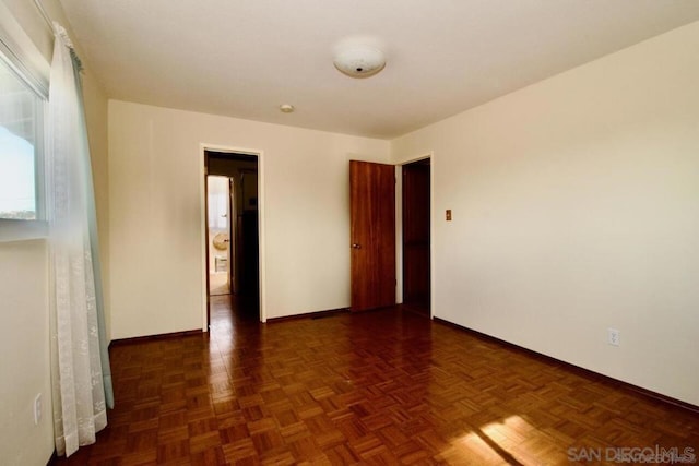 spare room featuring dark parquet flooring