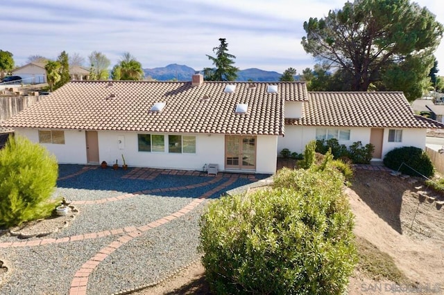 rear view of property with a mountain view and a patio area