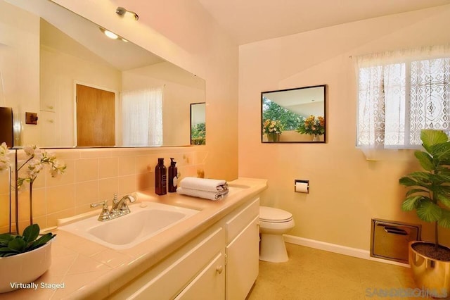 bathroom with decorative backsplash, lofted ceiling, toilet, and vanity