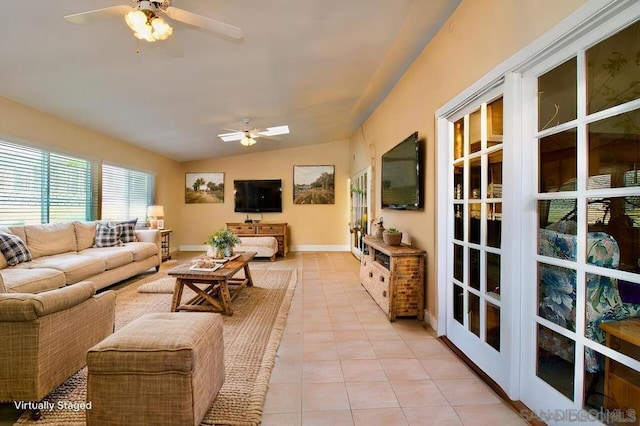 living room with ceiling fan, vaulted ceiling, and light tile patterned floors