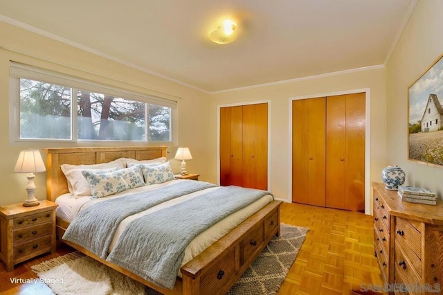 bedroom with multiple closets, light parquet flooring, and ornamental molding