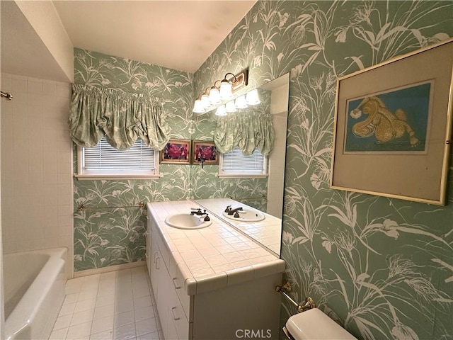 bathroom featuring toilet, a tub to relax in, tile patterned flooring, and vanity