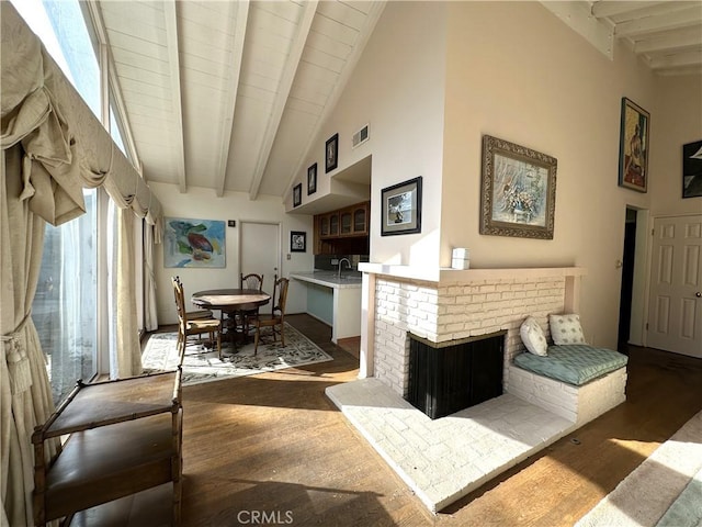 living room with sink, dark wood-type flooring, beamed ceiling, and high vaulted ceiling