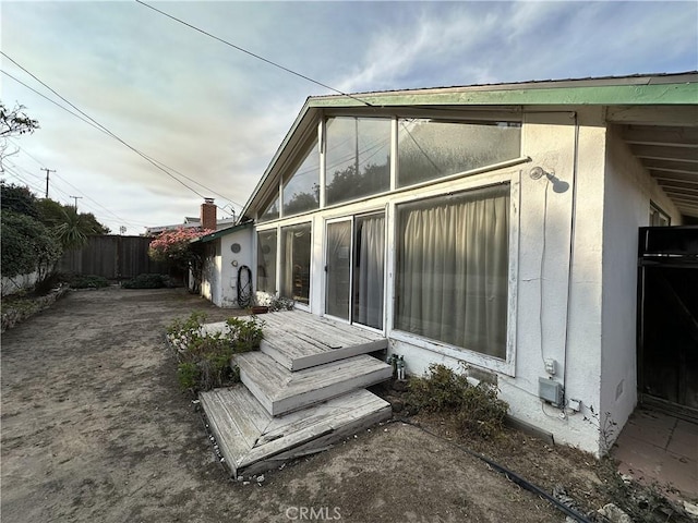 rear view of property featuring a wooden deck and a patio area