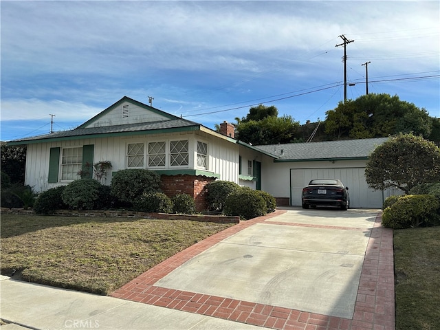 ranch-style home with a garage and a front lawn