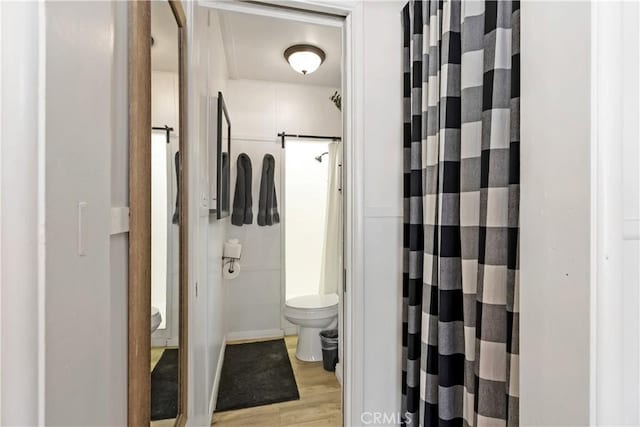 bathroom with toilet, walk in shower, and hardwood / wood-style floors