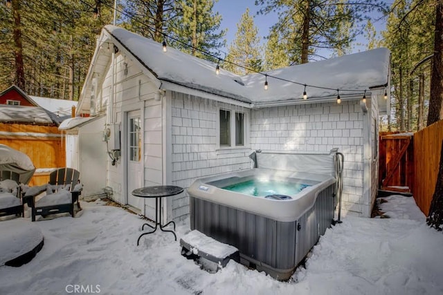 snow covered patio with a hot tub