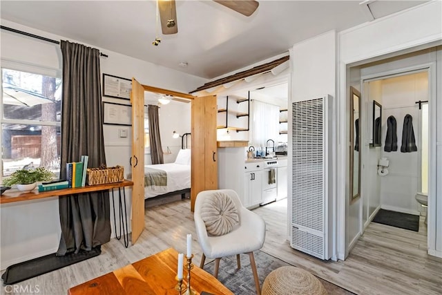 bedroom with ceiling fan, refrigerator, and light wood-type flooring