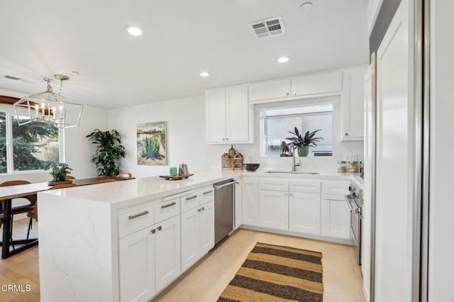 kitchen with sink, kitchen peninsula, white cabinets, and stainless steel appliances