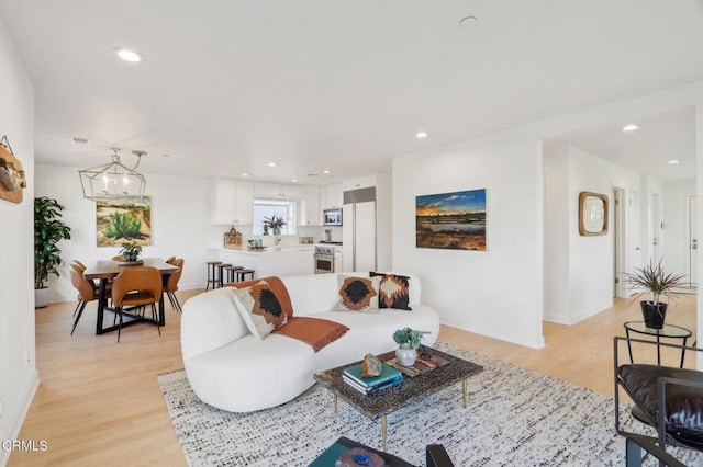 living room with light hardwood / wood-style floors and a chandelier