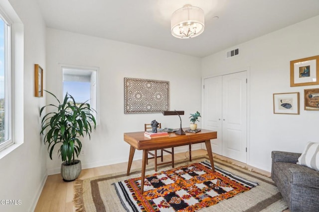 office featuring light hardwood / wood-style flooring and an inviting chandelier