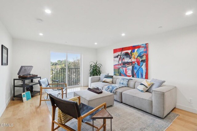 living area with light wood-style flooring, baseboards, and recessed lighting