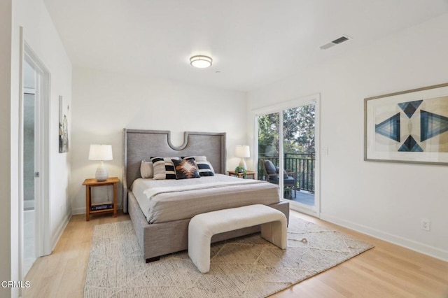 bedroom featuring baseboards, visible vents, light wood-style flooring, and access to outside