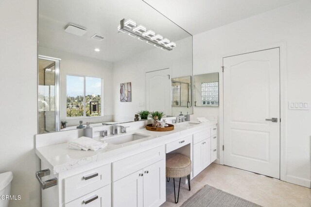 full bath featuring double vanity, visible vents, a sink, and toilet