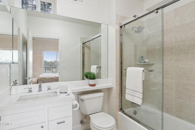 ensuite bathroom with toilet, vanity, combined bath / shower with glass door, and connected bathroom