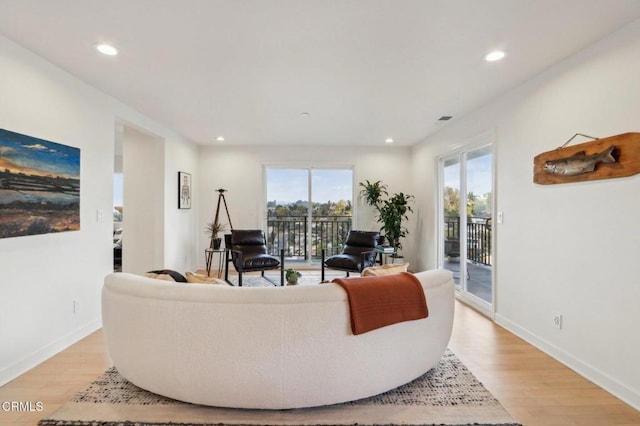 living area with baseboards, visible vents, recessed lighting, and light wood finished floors