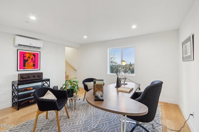 home office with light wood-style floors, baseboards, recessed lighting, and an AC wall unit