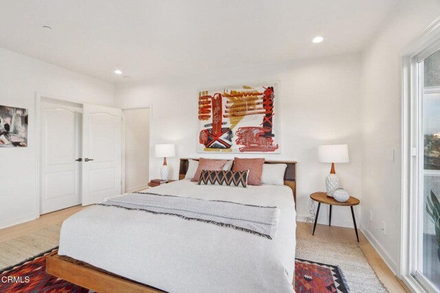 bedroom featuring baseboards, wood finished floors, and recessed lighting