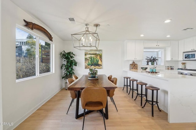 dining room featuring plenty of natural light, visible vents, and light wood finished floors
