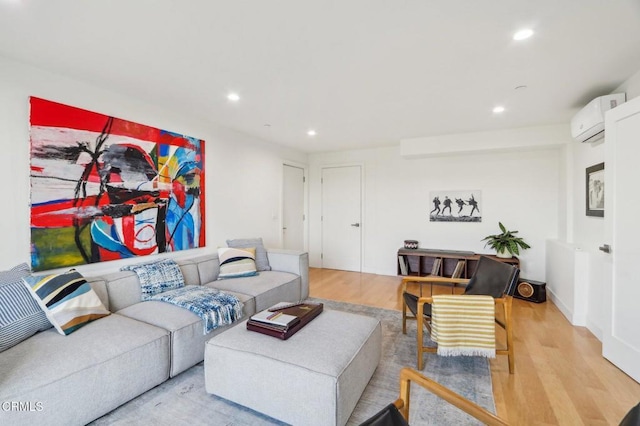 living room with a wall unit AC, recessed lighting, and light wood finished floors
