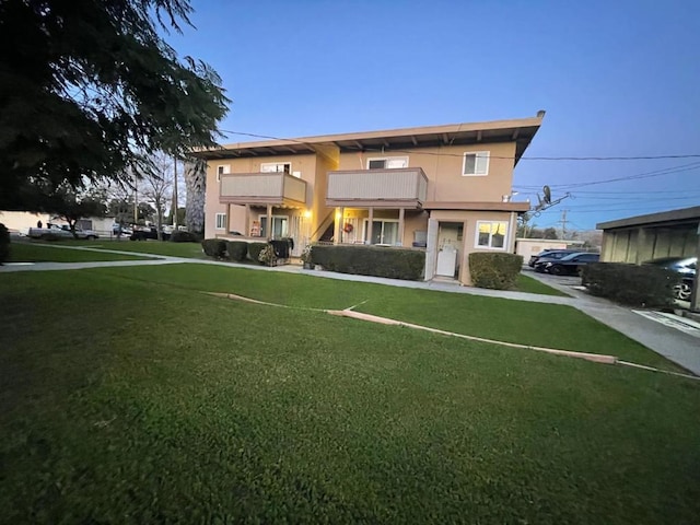 view of front of home featuring a front lawn and a balcony