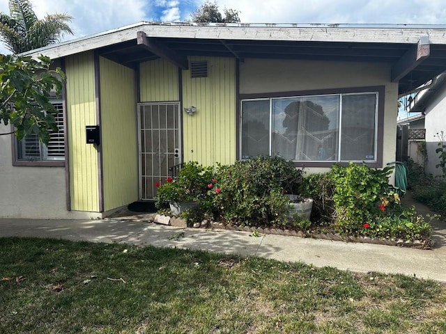 entrance to property with a lawn