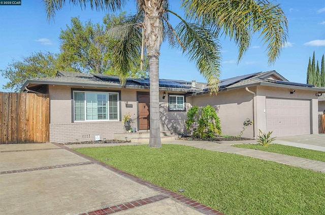 single story home featuring a garage, a front yard, and solar panels