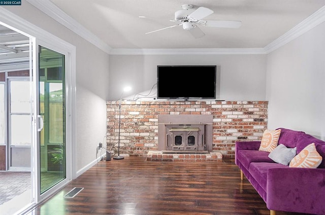 living room with dark hardwood / wood-style flooring, ornamental molding, ceiling fan, and a wood stove