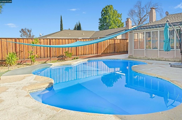 view of swimming pool featuring a patio area and a sunroom