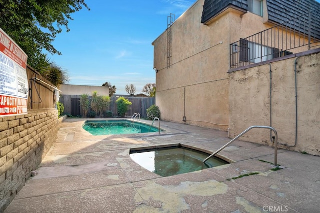 view of swimming pool featuring a community hot tub