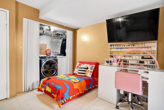 bedroom featuring independent washer and dryer and light tile patterned floors