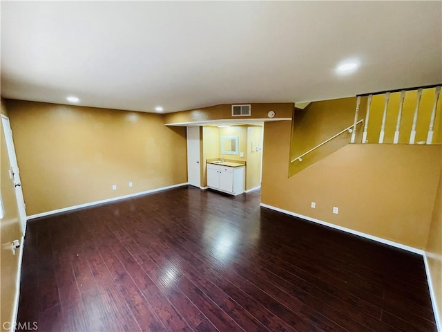 unfurnished living room with recessed lighting, visible vents, hardwood / wood-style floors, baseboards, and stairs