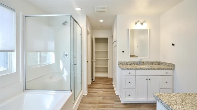 bathroom with wood-type flooring, vanity, and separate shower and tub