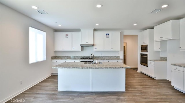 kitchen featuring white cabinets, a center island with sink, and stainless steel appliances