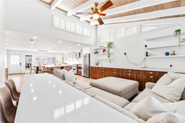 living room featuring wood ceiling, beamed ceiling, light hardwood / wood-style floors, and sink